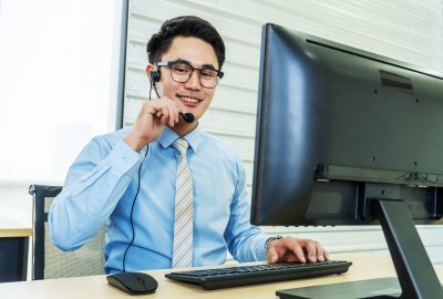 Call center, Service desk consultant talking on hands-free phone,  Portrait of happy smiling male customer support phone operator at workplace, Call center business man talking on headset, Office and business concept